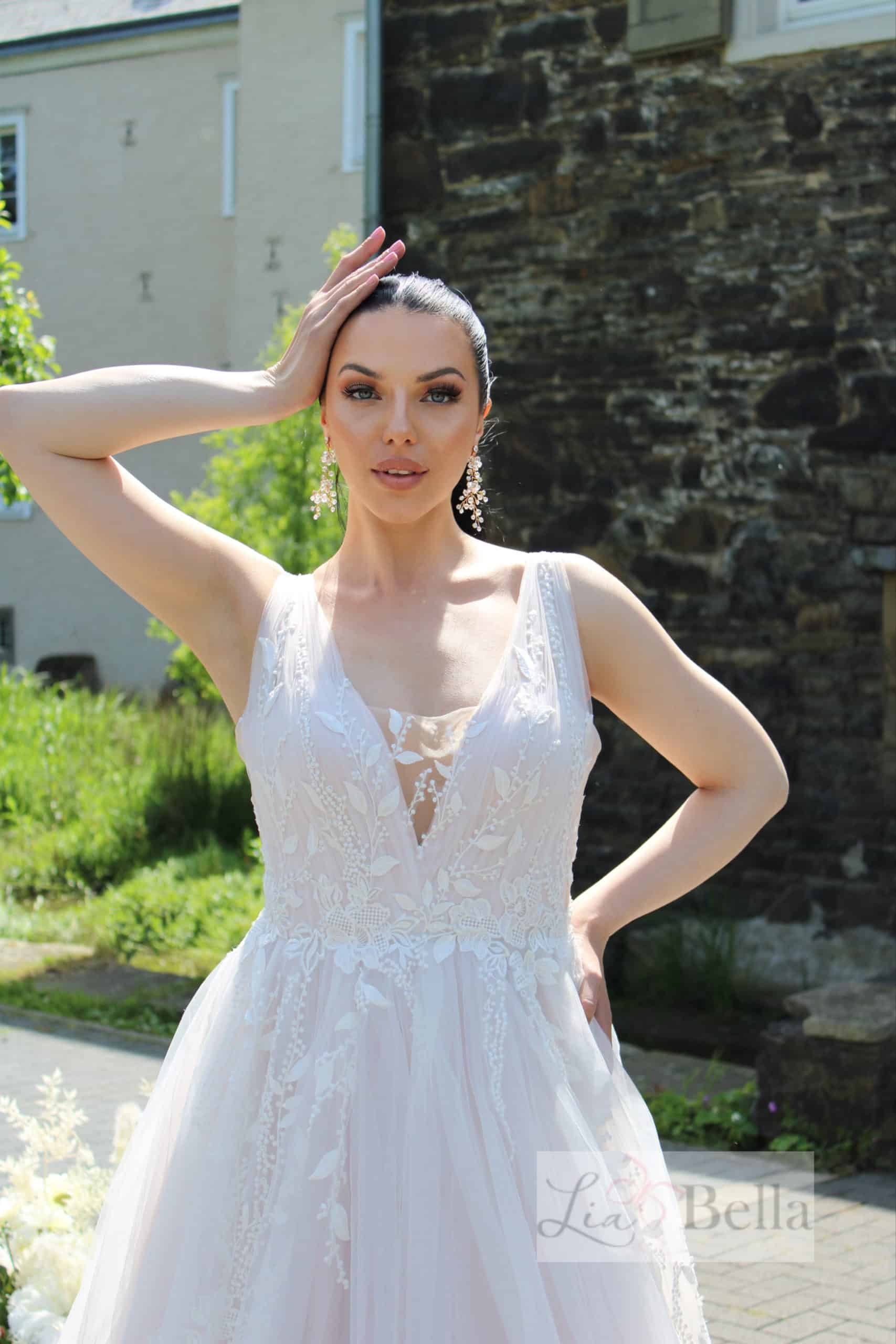 mandini Brautkleid LiaBella bei VeRina Brautmoden in Hille Rothenuffeln Träger V Ausschnitt gerafftes Oberteil zarte fließende Spitze Schleppe