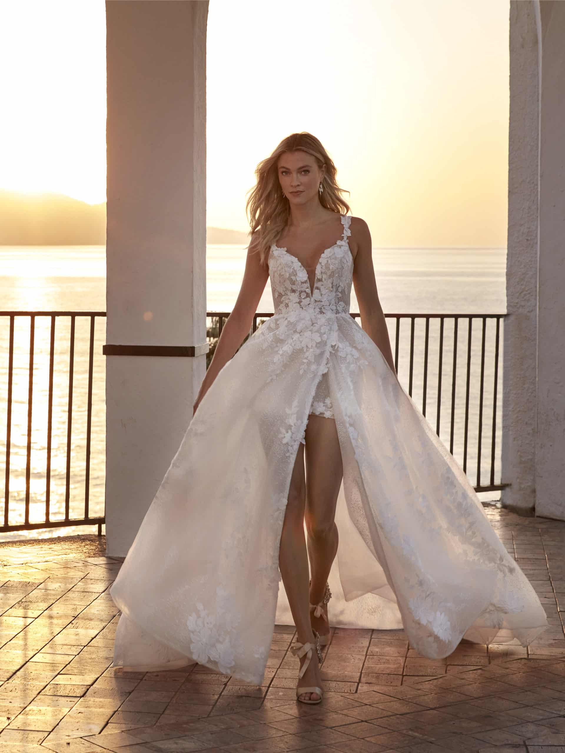 15017 Brautkleid Amelie bei VeRina Brautmoden in Hille Rothenuffeln fließende Spitze Glitzer hoher Schlitz mit kurzem Rock Spitzenträger tiefer Ausschnitt