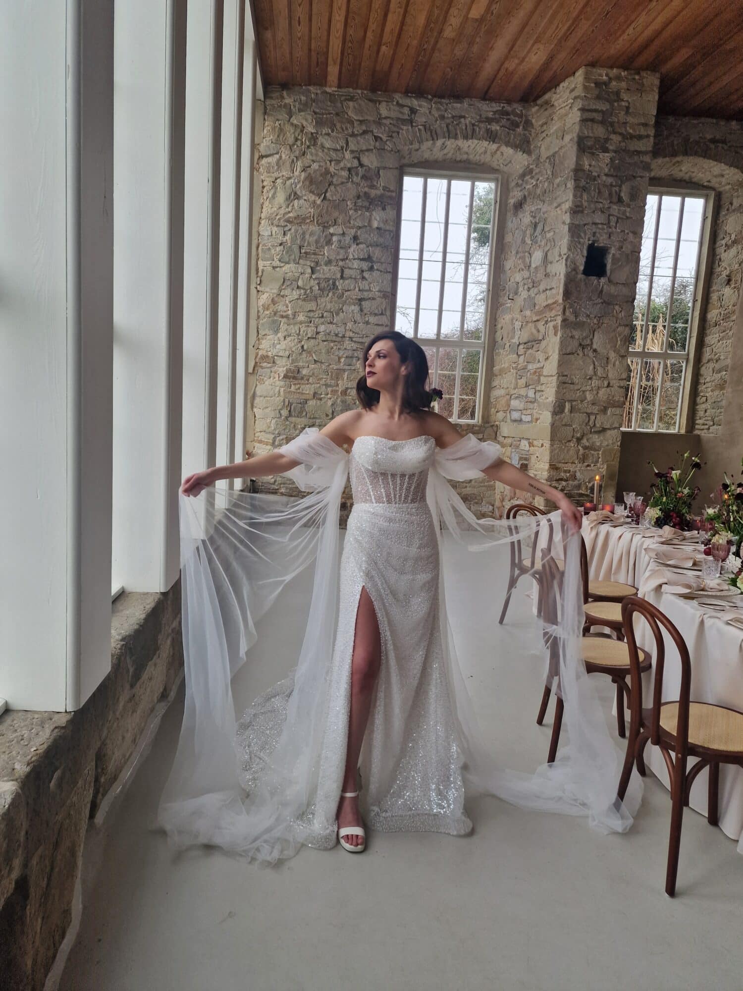 mediterrane hochzeit braut im kleid mit aermeln vor tisch